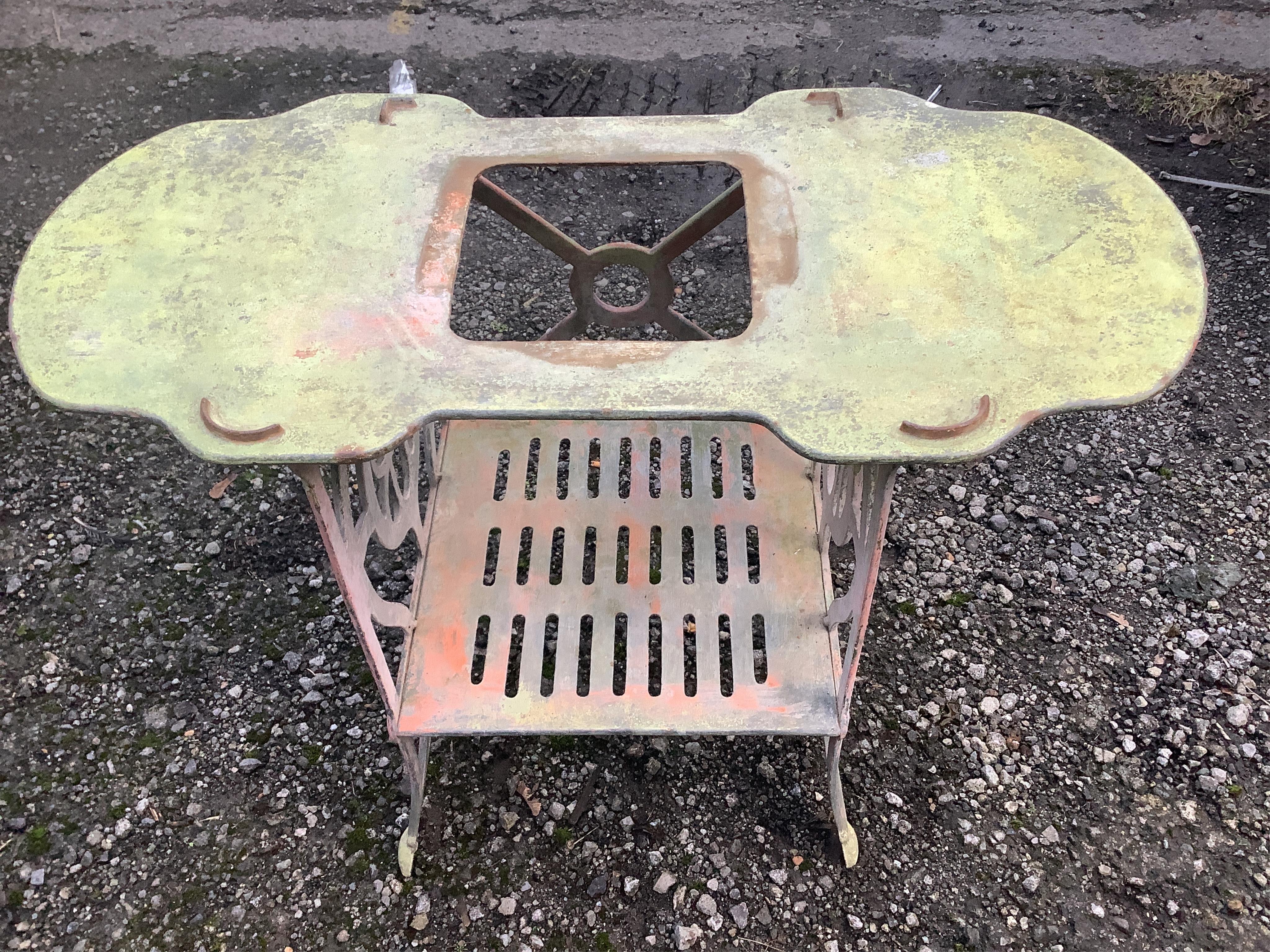 A small white painted cast metal two tier table, with a shaped top, width 78cm, height 59cm. Condition - fair